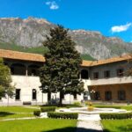 Una fotografia presa dal cortile del Conservatorio di Darfo, che mostra la struttura dell'edificio con le montagne sullo sfondo.