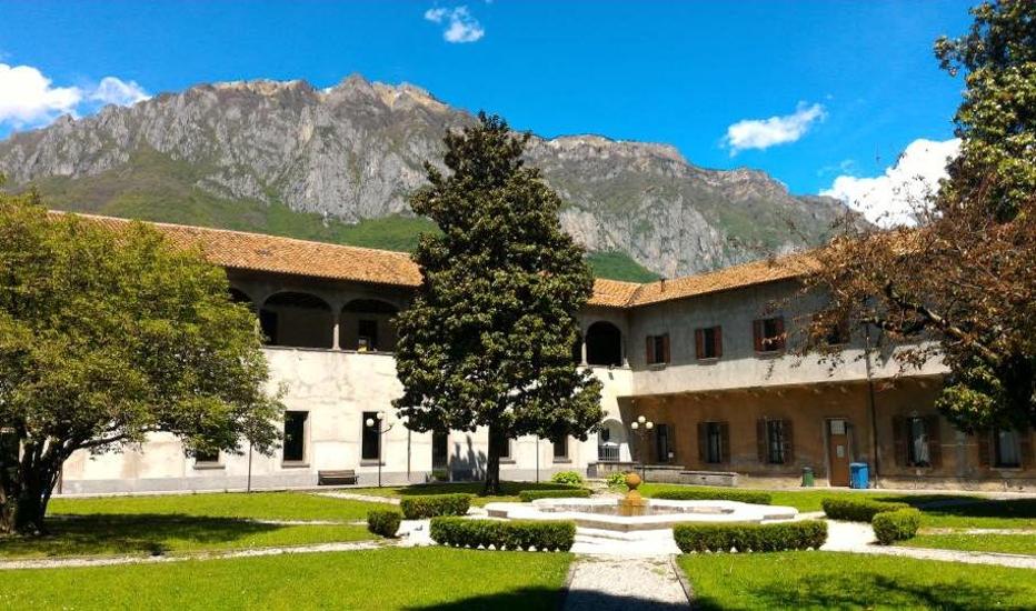 Una fotografia presa dal cortile del Conservatorio di Darfo, che mostra la struttura dell'edificio con le montagne sullo sfondo.